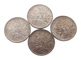 quatre types différents de pièces d'argent sur fond blanc