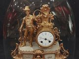a gold clock under a glass dome on a table