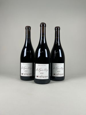 trois bouteilles de vin sont alignées sur une table