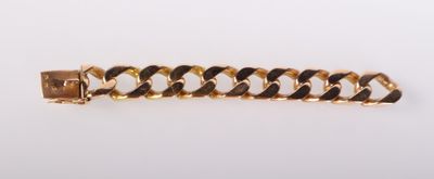 gros plan d'un bracelet en chaîne en or sur une surface blanche
