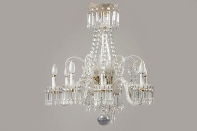 lustre en cristal à cinq lumières dans une pièce blanche