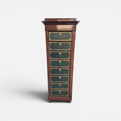 une petite commode en bois à quatre tiroirs, ornée de dorures