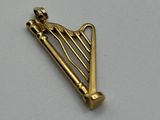 a close up of a gold harp shaped object on a white surface
