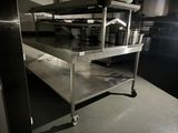 a metal shelf with pots and pans on it in a kitchen