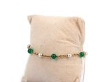 green and white beaded bracelet with pearls on a pillow