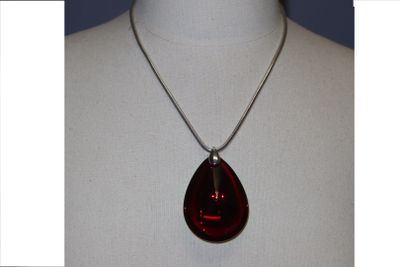 une photo d'un collier orné d'un pendentif rouge en forme de larme