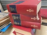 trois livres rouges empilés les uns sur les autres sur une table