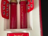two red perfume bottles in a red box with a gold lid