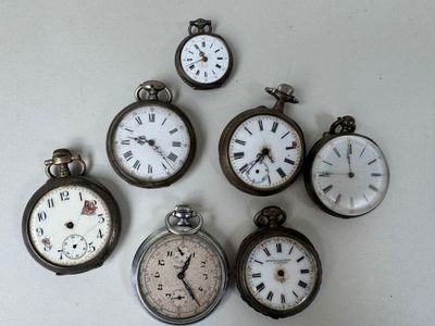 many different types of pocket watches displayed on a wall