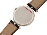 the back of a watch with a black leather band and a red stripe