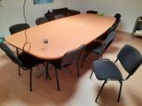 une grande table entourée de chaises dans une pièce