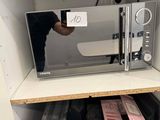 a microwave that is sitting on a shelf in a cabinet