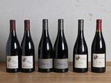 six bottles of wine are lined up on a wooden table