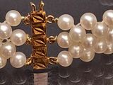 a close up of a bracelet with pearls on it