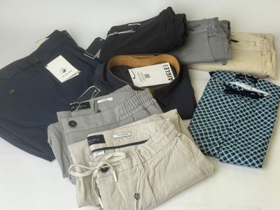 several pairs of men ' s pants laid out on a white surface