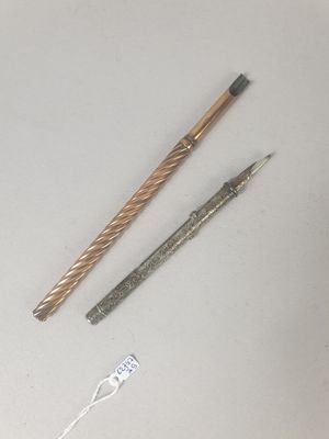 deux stylos et une brosse à dents posés sur une table