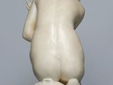 marble statue of a woman kneeling on a marble pedestal