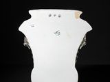 a white vase that is sitting on a black surface