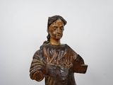 wooden statue of a woman holding a book in her hands