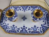 a blue and white plate with two cups on it