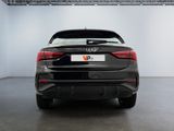 the rear end of a black car parked in a garage
