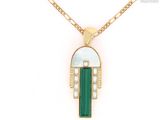 a close up of a necklace with a green stone on it