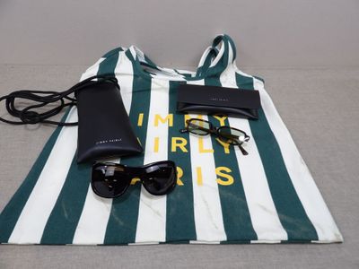 a bag with sunglasses, a cell phone, and a pair of sunglasses on it