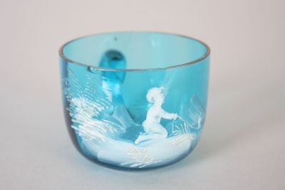 un verre en verre bleu sur lequel est représenté un homme dans un bateau