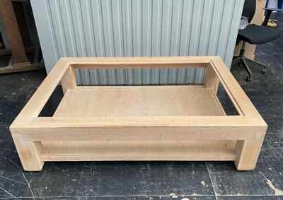a wooden coffee table with a glass top on the floor