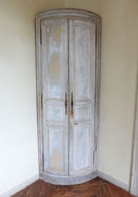 un coin d'une pièce avec un parquet et une armoire blanche
