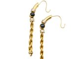 a pair of gold earrings with black stones on them