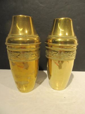 two gold vases sitting on a white table