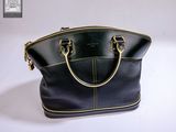 black and gold leather handbag on white surface with white background