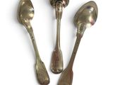 three spoons and a spoon rest on a white surface