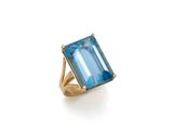 une bague en topaze bleue avec un anneau en or et une émeraude