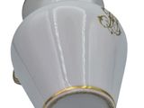 a white vase with a gold trim on it