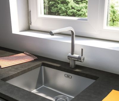 un évier de cuisine avec un robinet, devant une fenêtre