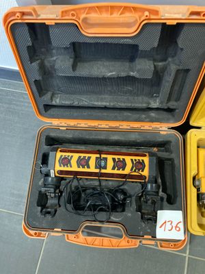 une mallette jaune posée par terre, contenant des outils