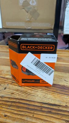 une boîte orange et noire contenant des piles Black & Decker, posée sur une table en bois