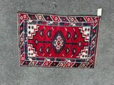 a close up of a red and blue rug on the ground