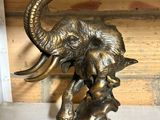 a statue of an elephant with a baby elephant on it ' s back