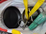 a lot of cooking utensils and a pan on the table