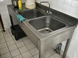 un évier en acier inoxydable dans une cuisine équipée d'un siphon