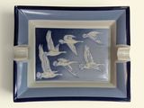 une assiette bleue et blanche sur laquelle est représenté un motif d'oiseaux