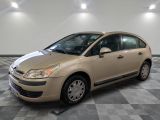La voiture beige est garée dans le garage, sur le sol à carreaux.