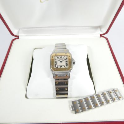 a silver and gold watch in a red box