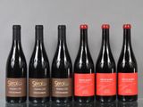 six bottles of wine are lined up on a table