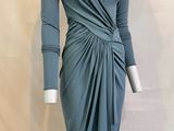 Le mannequin porte une robe grise à manches longues.