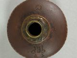 a brown vase with a black hole in the middle