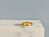 une bague en or posée sur un bloc de marbre